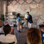 Happy young male manager standing on business team brainstorming